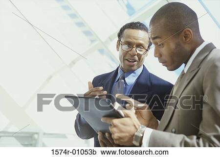 Two businessmen talking View Large Photo Image Stock Image - Two businessmen talking. Fotosearch