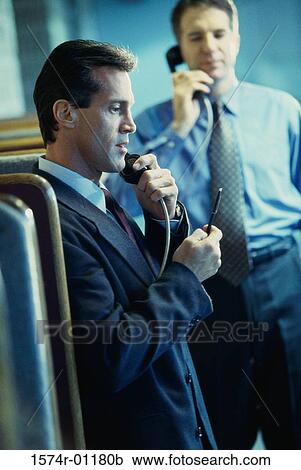 Two businessmen using pay phones View Large Photo Image Stock Image - Two businessmen using pay phones. Fotosearch
