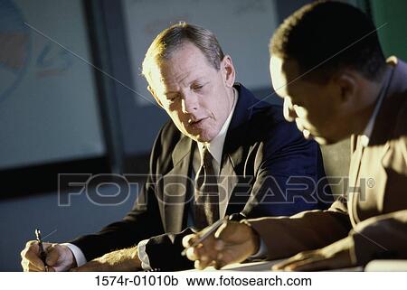 Two businessmen working in an office View Large Photo Image Stock Image - Two businessmen working in an office. Fotosearch