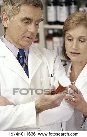 Stock Photograph - Two doctors looking at a bottle of pills. Fotosearch