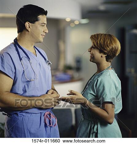 Stock Image - Two doctors talking face to face. Fotosearch