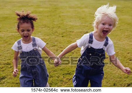 Two girls running on a lawn View Large Photo Image Stock Image - Two girls running on a lawn. Fotosearch