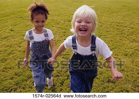 Two girls running on a lawn View Large Photo Image Stock Image - Two girls running on a lawn. Fotosearch