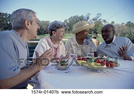Two senior couples seated at a table talking View Large Photo Image Stock Image - Two senior couples seated at a table talking. Fotosearch