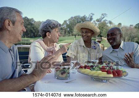 Two senior couples seated at a table talking View Large Photo Image Stock Image - Two senior couples seated at a table talking. Fotosearch