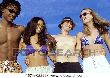 Stock Image - Two teenage couples on the beach. Fotosearch