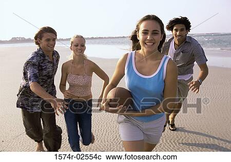 Two teenage couples playing football on the beach View Large Photo Image Stock Image - Two teenage couples playing football on the beach. Fotosearch