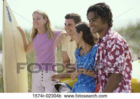 Two teenage couples standing beside a car View Large Photo Image Stock Image - Two teenage couples standing beside a car. Fotosearch