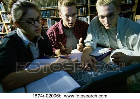 Two young men and a young woman using a laptop View Large Photo Image Stock Image - Two young men and a young woman using a laptop. Fotosearch