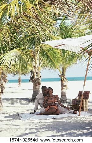 Stock Image - Young couple embracing on the beach. Fotosearch