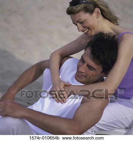 Young couple holding each other at the beach View Large Photo Image Stock Image - Young couple holding each other at the beach. Fotosearch