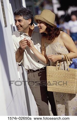 Stock Image - Young couple looking through a store window. Fotosearch