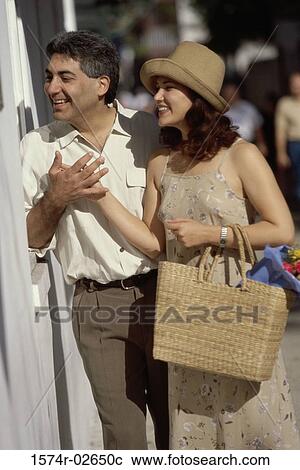 Young couple looking through a store window View Large Photo Image Stock Image - Young couple looking through a store window. Fotosearch