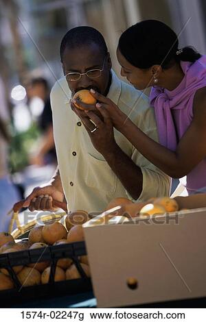 Young couple picking oranges from a shop in a market View Large Photo Image Stock Image - Young couple picking oranges from a shop in a market. Fotosearch