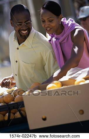 Stock Image - Young couple shopping in the market. Fotosearch