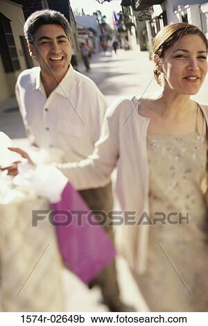 Young couple walking with shopping bags View Large Photo Image Stock Image - Young couple walking with shopping bags. Fotosearch