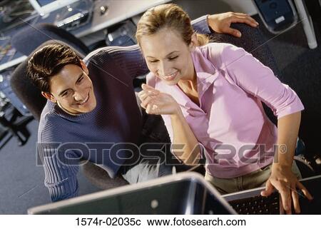 Young man and a young woman looking at a computer monitor View Large Photo Image Stock Image - Young man and a young woman looking at a computer monitor. Fotosearch