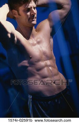 Stock Image - Young man flexing his muscles. Fotosearch
