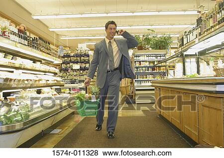 Young man in a grocery store View Large Photo Image Stock Photo - Young man in a grocery store. Fotosearch