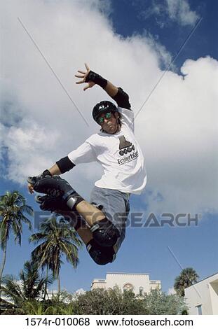 Young man jumping in mid air wearing inline skates View Large Photo Image Stock Photo - Young man jumping in mid air wearing inline skates. Fotosearch