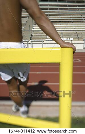 Young man leaning on a hurdle View Large Photo Image Stock Image - Young man leaning on a hurdle. Fotosearch