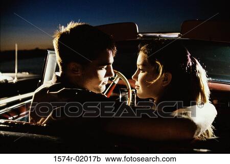 Young man sitting with a teenage girl in a convertible car View Large Photo Image Stock Image - Young man sitting with a teenage girl in a convertible car. Fotosearch