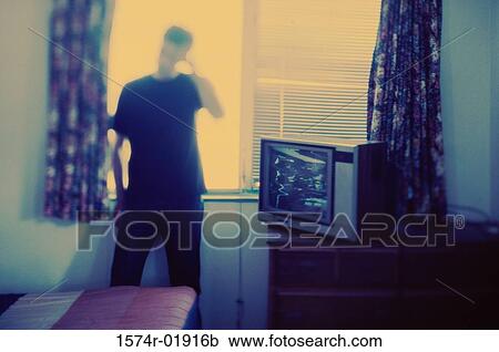 Young man standing beside a television View Large Photo Image Stock Image - Young man standing beside a television. Fotosearch