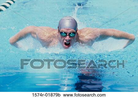 Young man swimming in a swimming pool View Large Photo Image Stock Image - Young man swimming in a swimming pool. Fotosearch