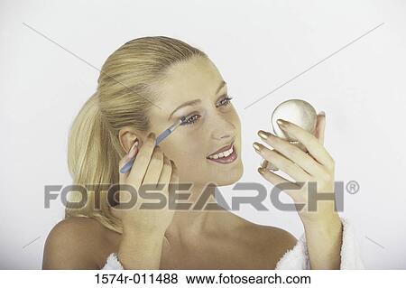 Stock Photo - Young woman applying eye make-up. Fotosearch