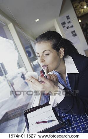 Young woman applying lipstick View Large Photo Image Stock Photo - Young woman applying lipstick. Fotosearch