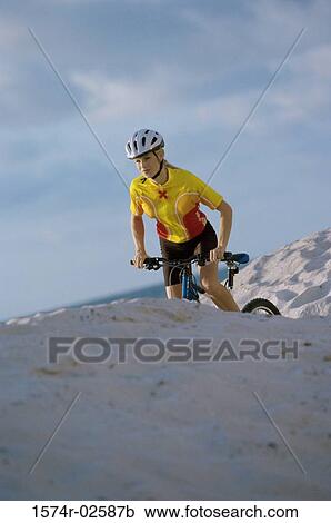 Young woman cycling on sand View Large Photo Image Stock Image - Young woman cycling on sand. Fotosearch