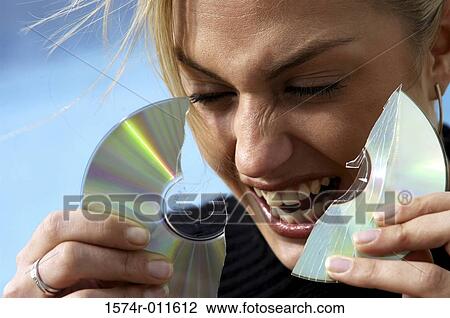 Young woman holding a broken CD View Large Photo Image Stock Image - Young woman holding a broken CD. Fotosearch
