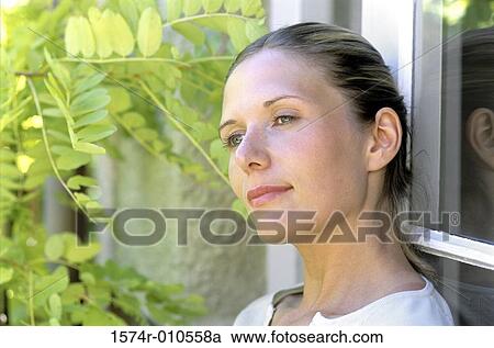 Young woman leaning against a window View Large Photo Image Stock Image - Young woman leaning against a window. Fotosearch