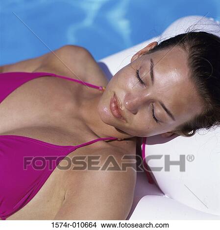 Young woman lying beside a swimming pool View Large Photo Image Picture - Young woman lying beside a swimming pool. Fotosearch