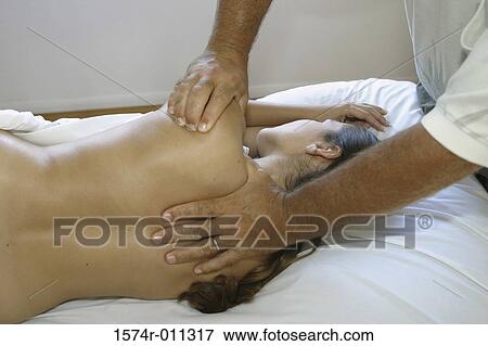 Stock Photo - Young woman lying down getting a back massage. Fotosearch