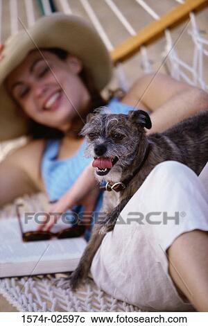 Young woman lying in a hammock with her dog View Large Photo Image Stock Image - Young woman lying in a hammock with her dog. Fotosearch