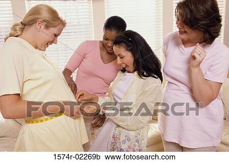 Young woman measuring a pregnant woman's abdomen View Large Photo Image Stock Image - Young woman measuring a pregnant woman's abdomen. Fotosearch