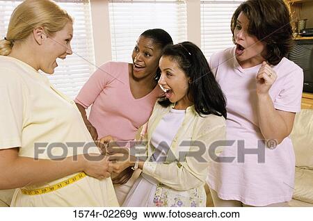 Young woman measuring a pregnant woman's abdomen View Large Photo Image Stock Image - Young woman measuring a pregnant woman's abdomen. Fotosearch