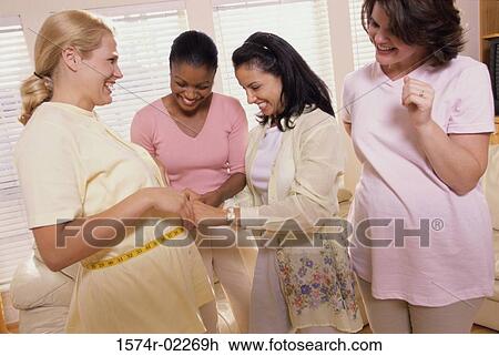 Young woman measuring a pregnant woman's abdomen View Large Photo Image Stock Image - Young woman measuring a pregnant woman's abdomen. Fotosearch