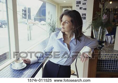 Stock Photography - Young woman standing at a window. Fotosearch