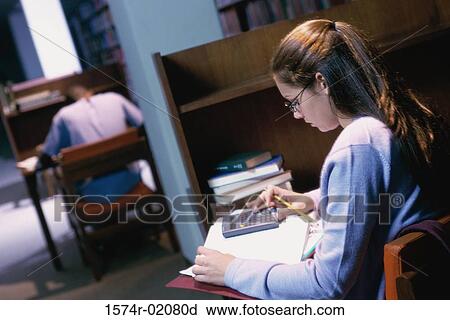 Young woman studying in a library View Large Photo Image Stock Image - Young woman studying in a library. Fotosearch