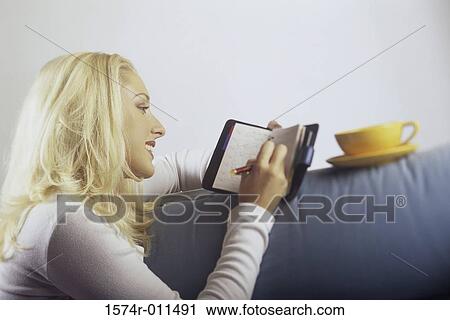 Young woman writing in a planner View Large Photo Image Stock Image - Young woman writing in a planner. Fotosearch