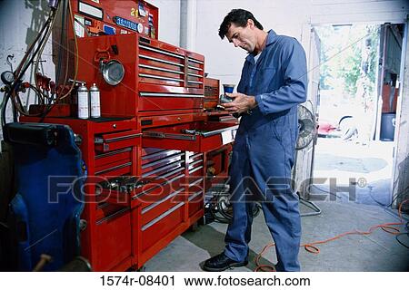 Auto mechanic standing near a toolbox in a garage View Large Photo Image Stock Image - Auto mechanic standing near a toolbox in a garage. Fotosearch