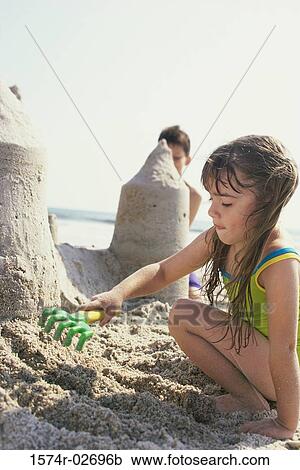 Boy and a girl making sand castles on the beach View Large Photo Image Stock Image - Boy and a girl making sand castles on the beach. Fotosearch