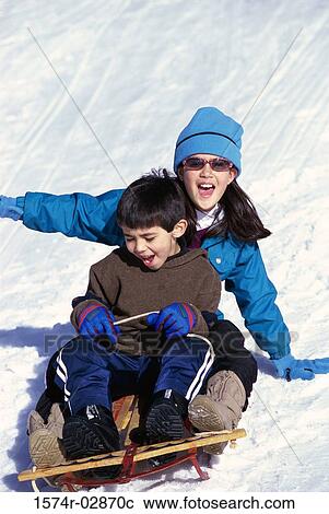Boy and a girl riding a sled View Large Photo Image Stock Image - Boy and a girl riding a sled. Fotosearch