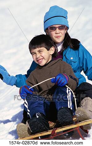 Stock Image - Boy and a girl riding a sled. Fotosearch