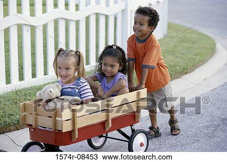 Boy and two girls playing with a push cart View Large Photo Image Stock Image - Boy and two girls playing with a push cart. Fotosearch