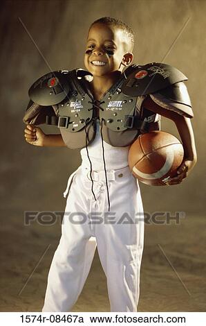 Boy in a football uniform holding a ball View Large Photo Image Stock Image - Boy in a football uniform holding a ball. Fotosearch