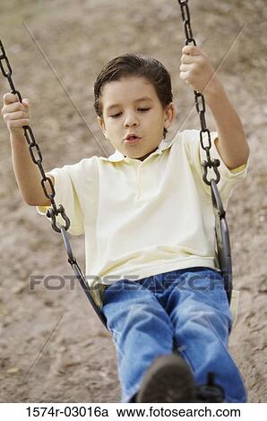 Boy sitting on a swing View Large Photo Image Stock Image - Boy sitting on a swing. Fotosearch