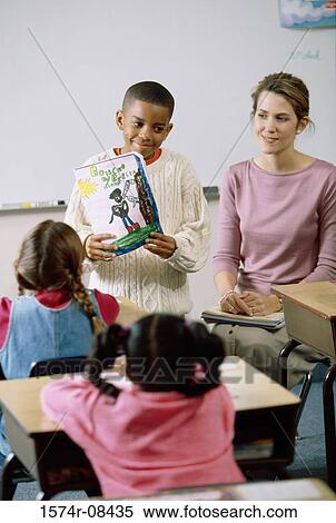 Stock Photography - Boy standing at the front of the class during show-and-tell. Fotosearch